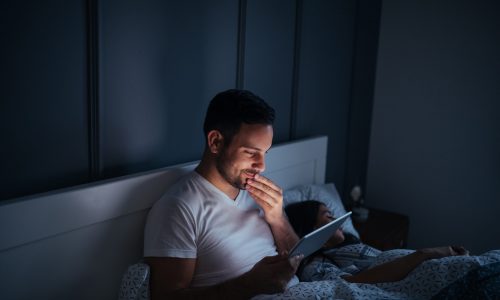 Man watching series online in bed.